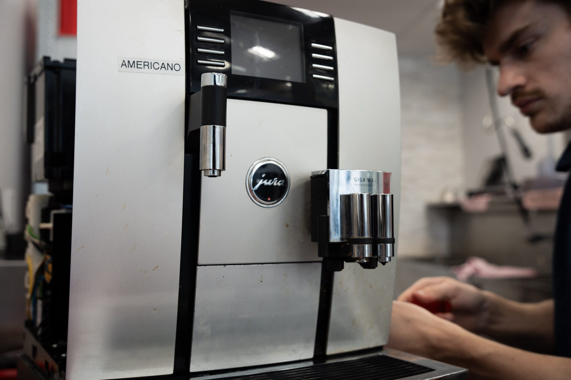 Technician inspecting Jura espresso machine during service repair