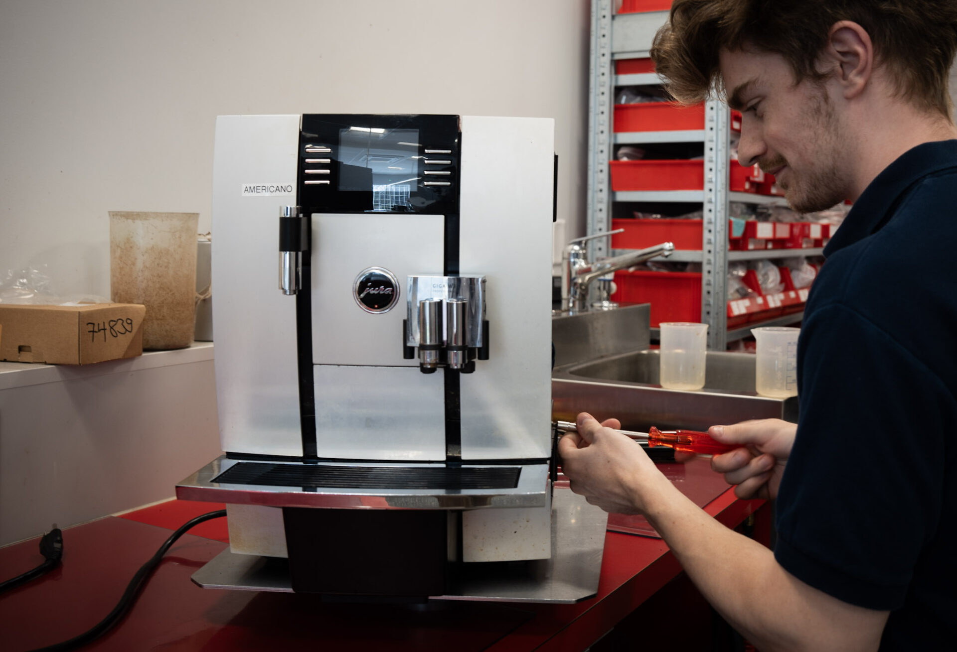 Full view of technician repairing Jura espresso unit