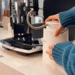 JURA milk carafe inside of a JURA glacette, next to a machine